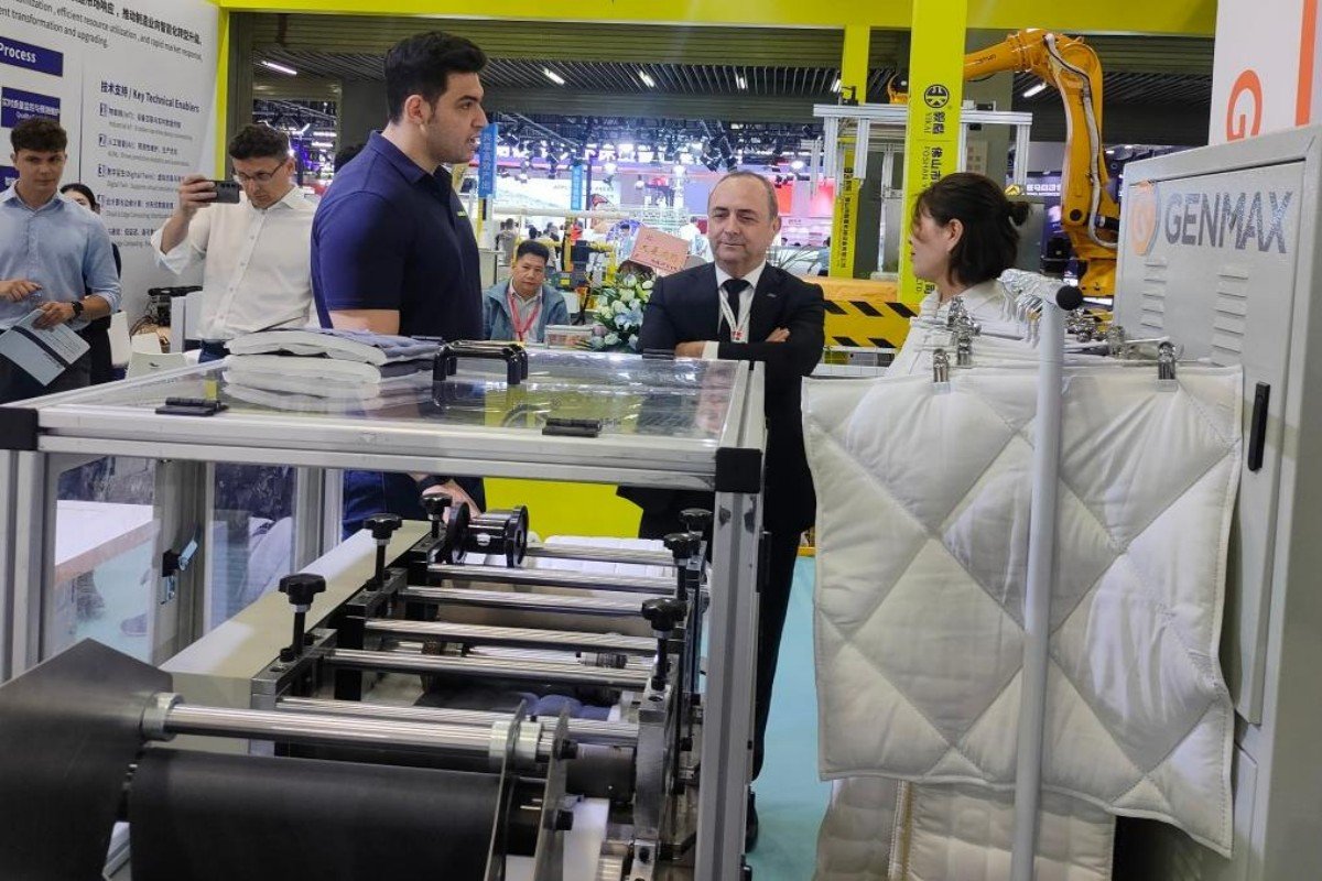 Customers at the GENMAX CIFF Guangzhou booth carefully inspecting fabric samples for quality and compatibility.