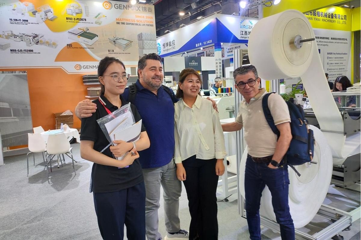 GENMAX team and customers taking a commemorative photo in front of the displayed quilting machine at CIFF Guangzhou.