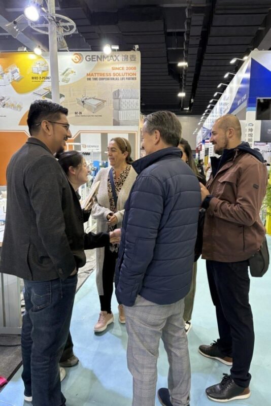 Customer taking close-up photos of GENMAX machine features for later review at the CIFF exhibition.