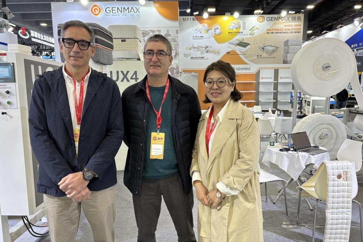 Customer receiving a detailed product brochure from a GENMAX team member at the CIFF exhibition booth.