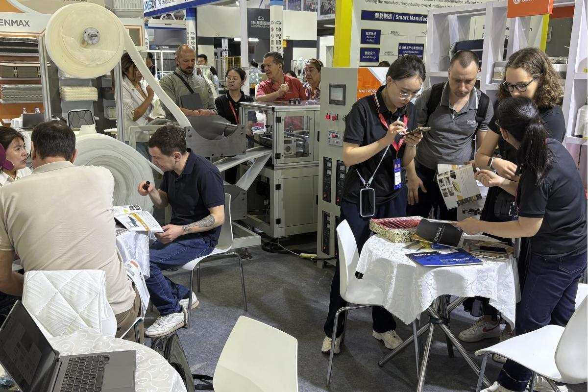 Customer engaging with a GENMAX engineer, asking detailed technical questions about machine performance at CIFF Guangzhou