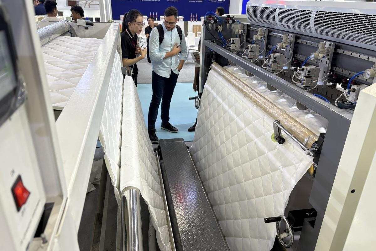 GENMAX specialist and customer having an in-depth discussion about fabric types and machine compatibility at CIFF Guangzhou.