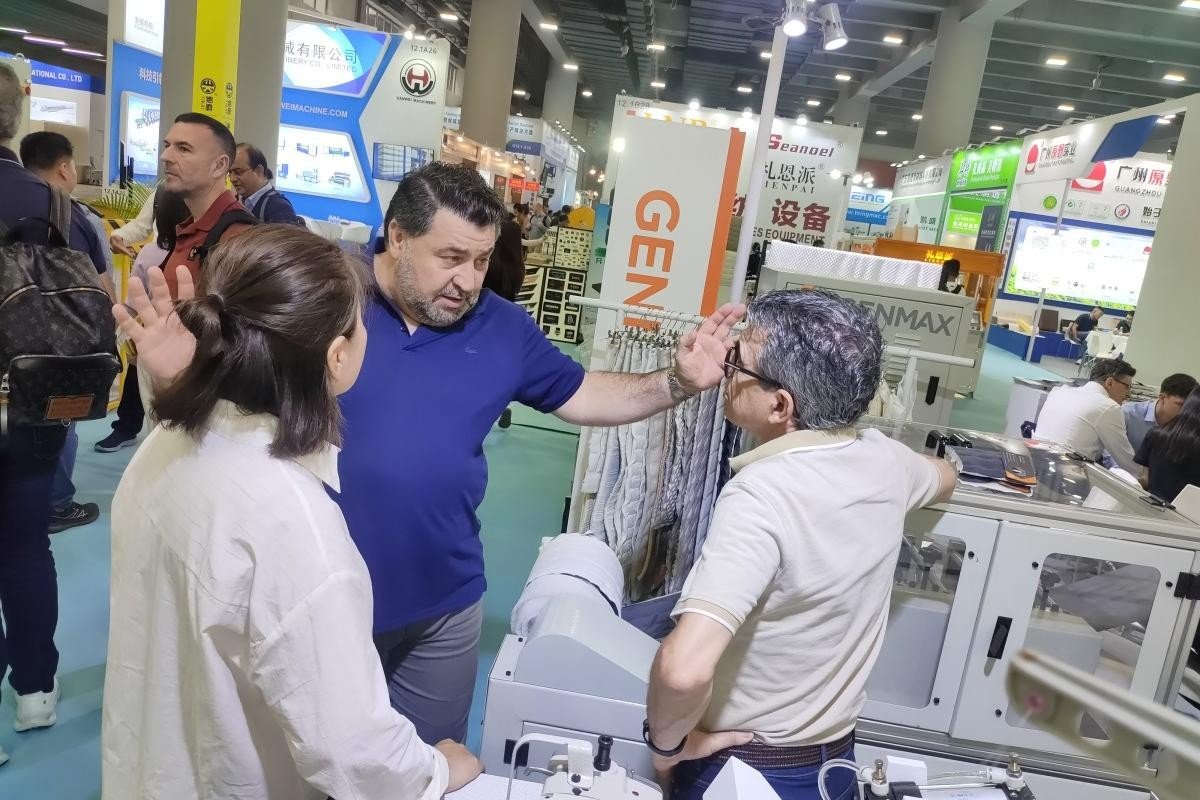 GENMAX specialists and customers discussing different fabric types and their compatibility with quilting machinery at CIFF Guangzhou.
