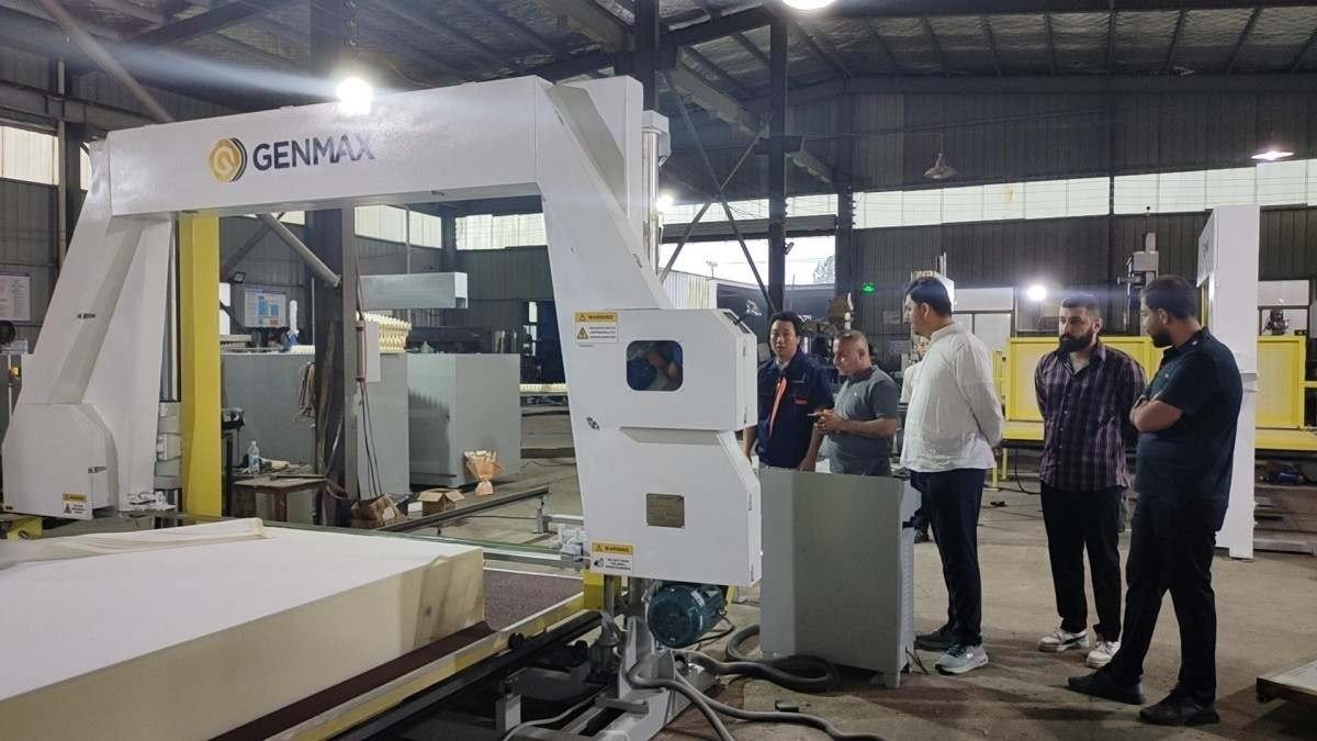 Iraqi delegates getting hands-on experience operating the advanced sponge edge cutting machine under supervision during their factory visit.