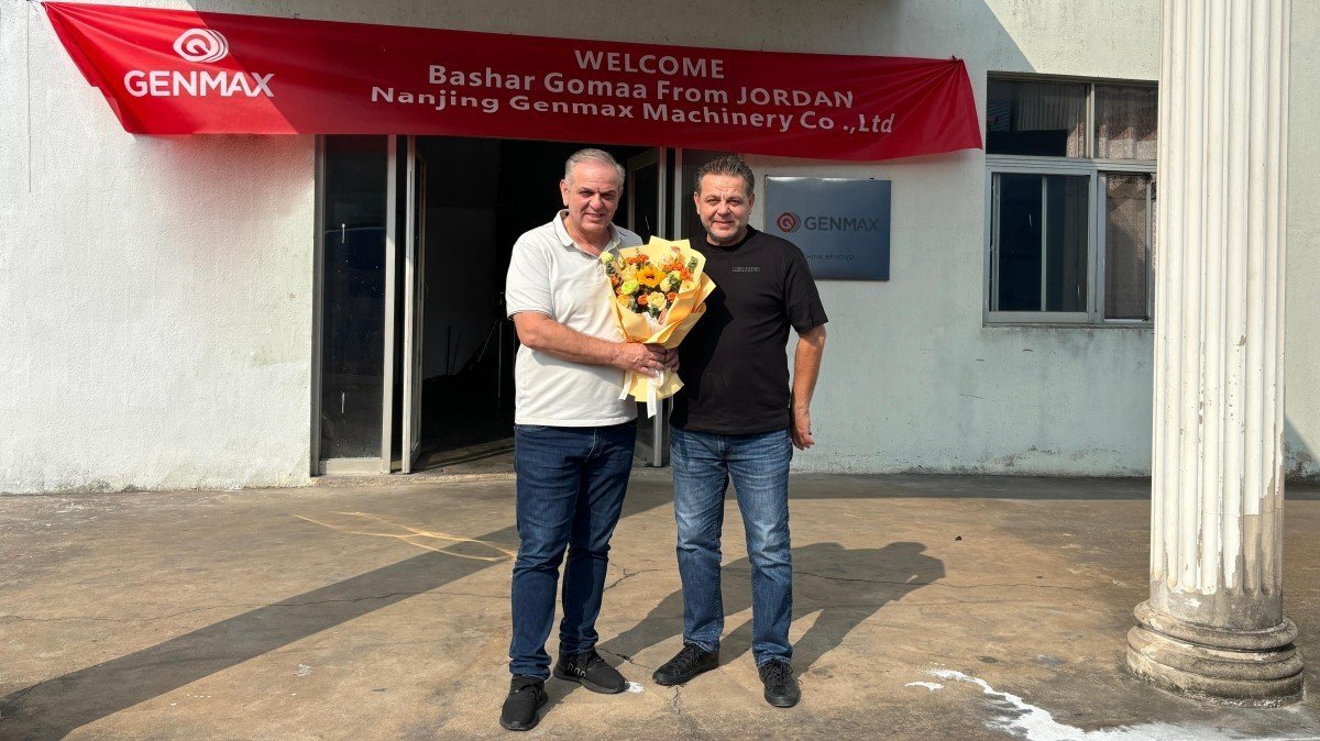 Jordanian business delegation posing for a commemorative group photograph with company representatives at the factory main entrance following their comprehensive tour of mattress manufacturing equipment.