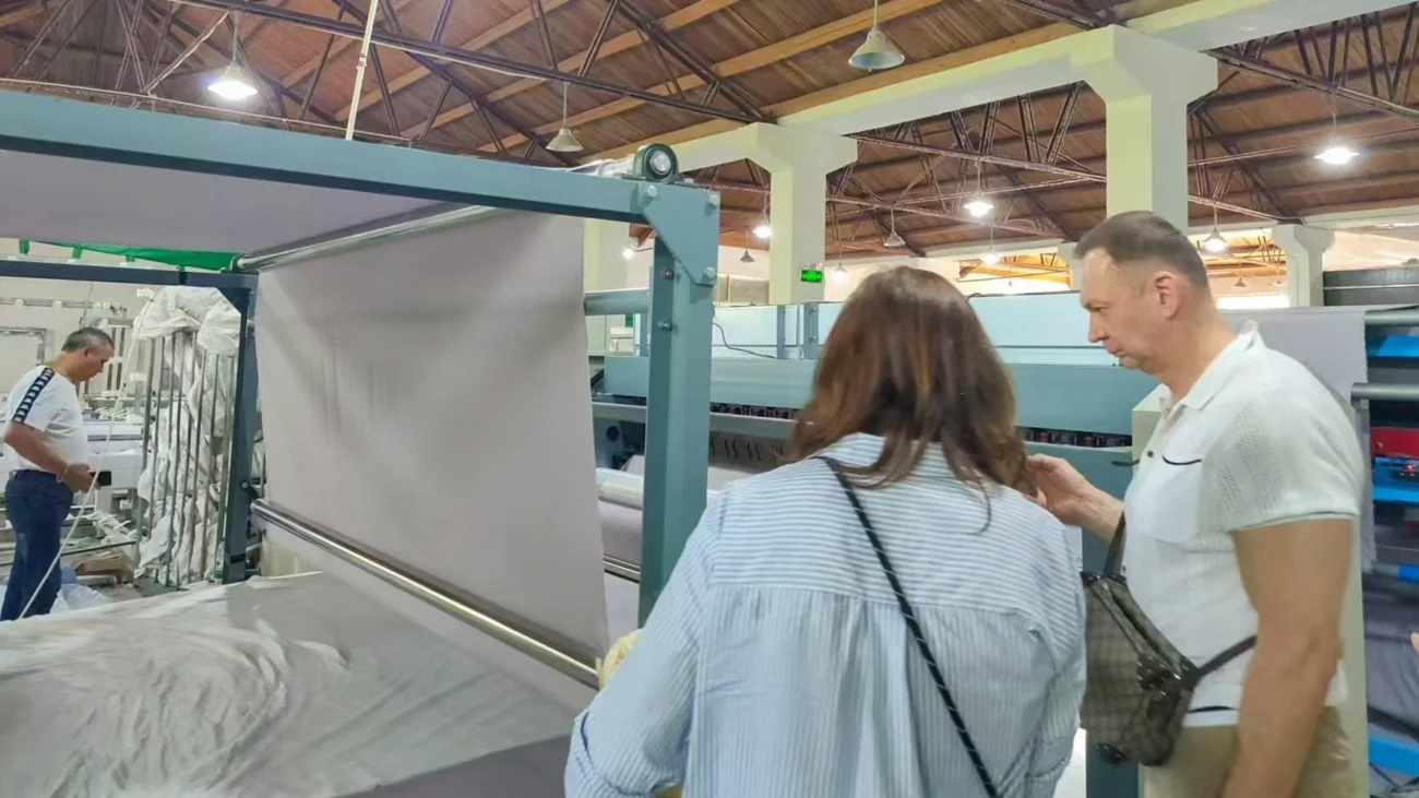 Group of customer representatives discussing features of the textile manufacturing machine