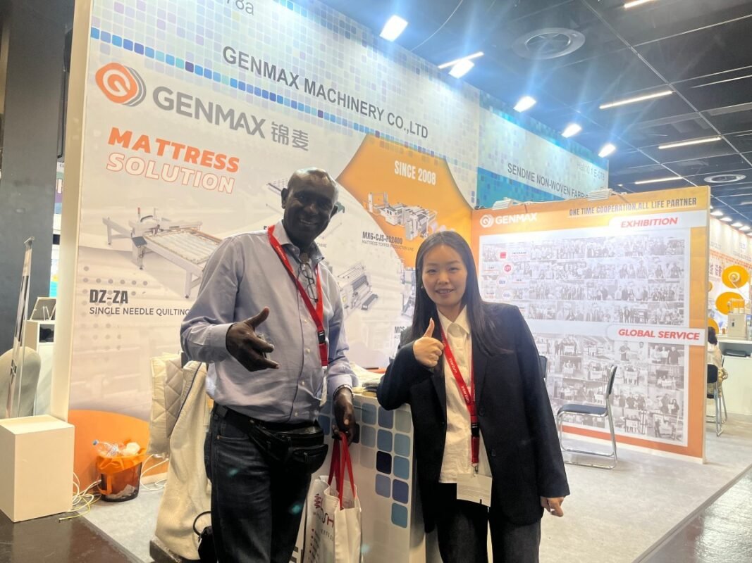 Textile industry delegation from Kenya examining GENMAX quilting equipment capabilities and automation solutions at their Booth 9-542 during Interzum 2025 trade show.