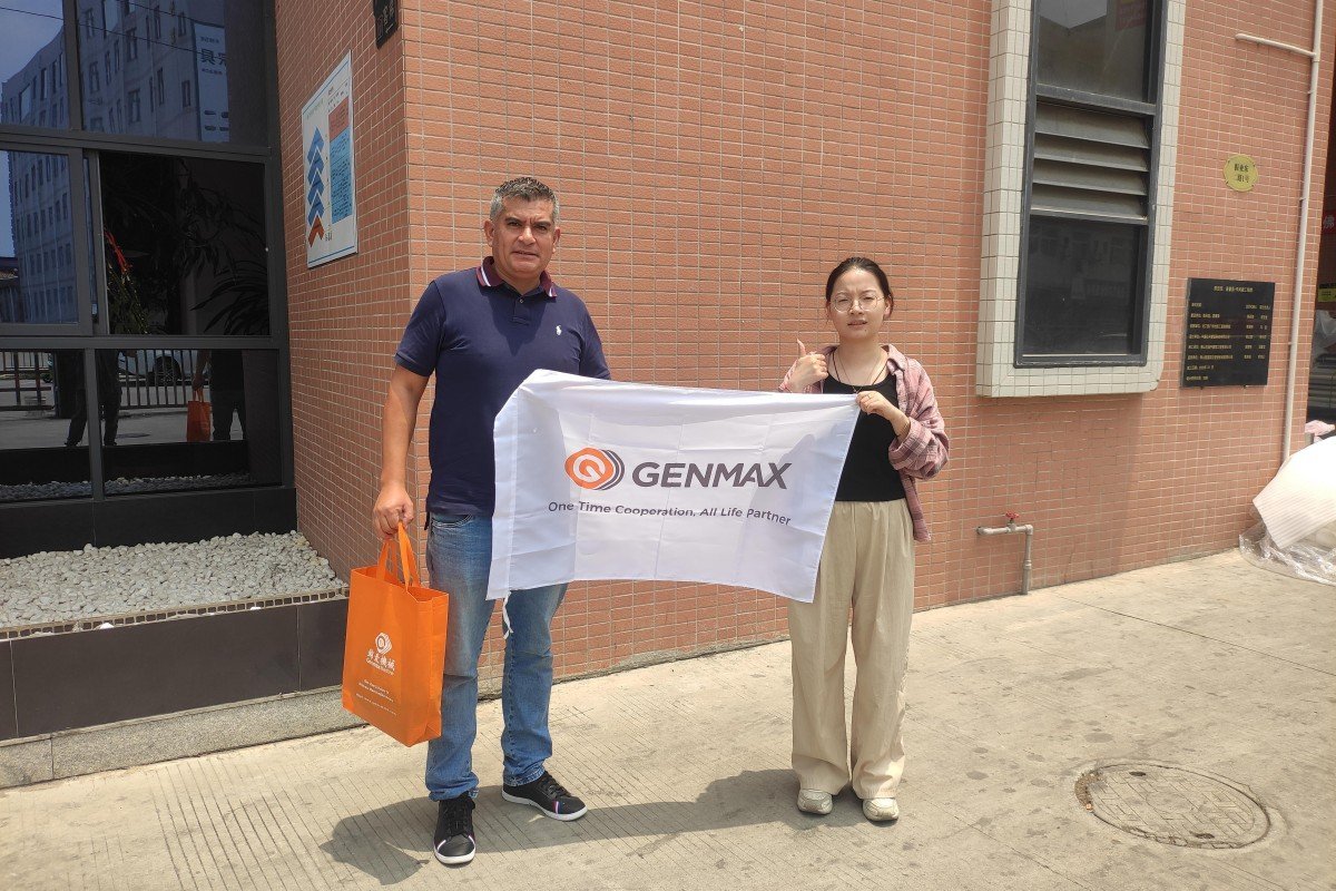 Manufacturing team posing for a commemorative photograph with visiting Peruvian textile industry representatives at the quilting machine factory entrance after a comprehensive facility tour.