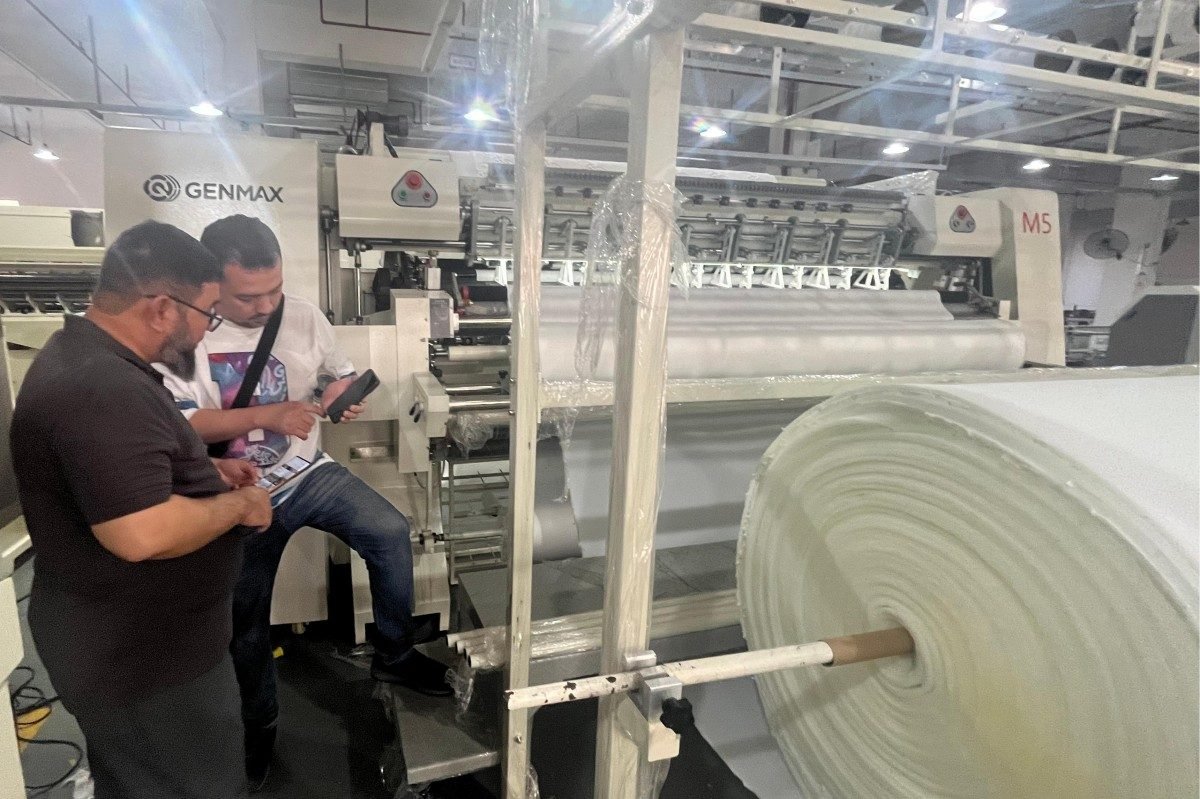 Technical specialists demonstrating quilting machine performance metrics to Saudi Arabian customers conducting thorough equipment assessment before finalizing their procurement decisions.